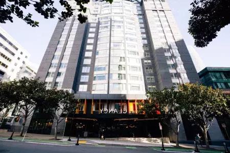 Clancy Hotel SF的外观, 高大的灰白色建筑，前面环绕着树木.